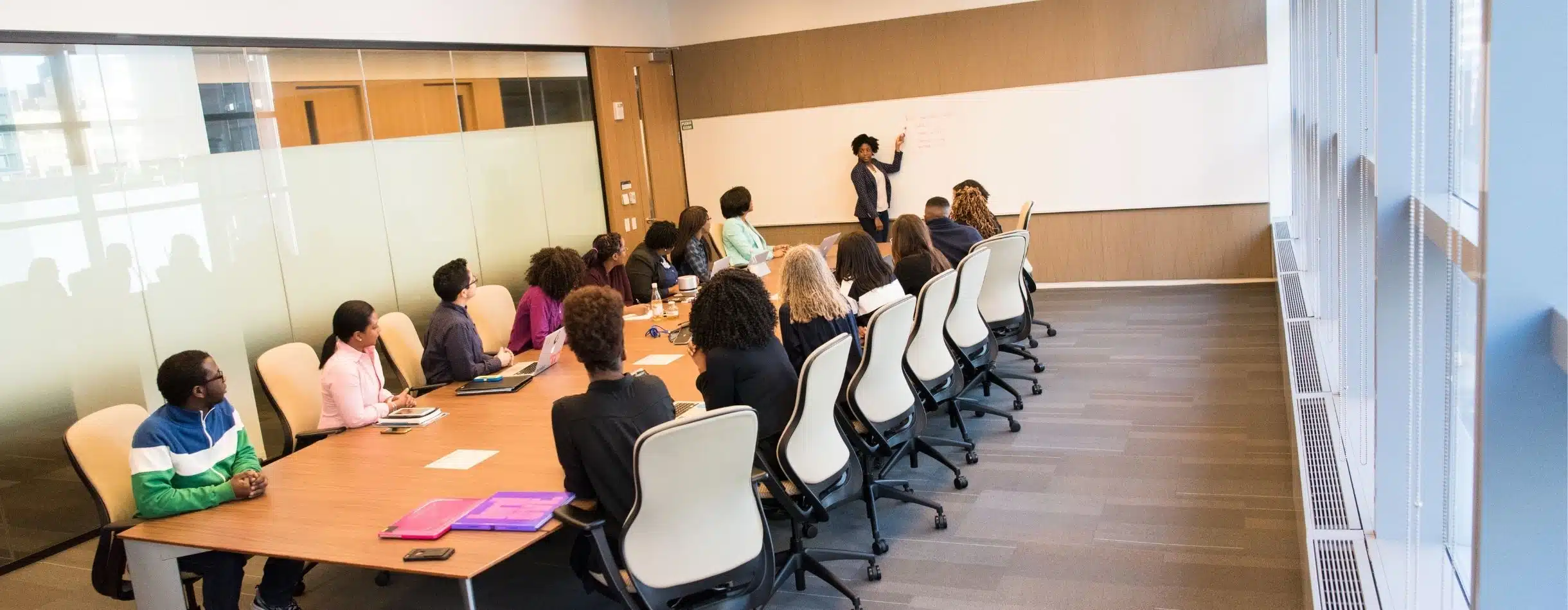 Several team members are watching a presentation unfold in a conference room.