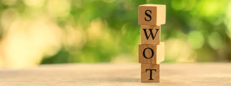 Building blocks spelling out SWOT with trees in the background