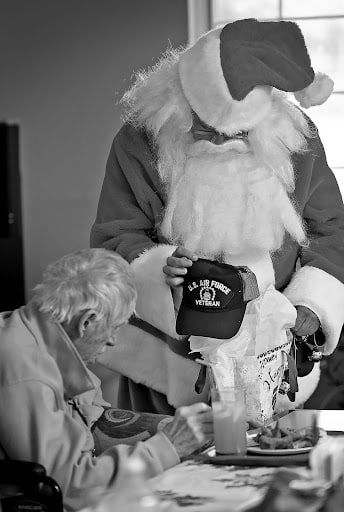 This is an excellent example of nonprofit storytelling via email. This image shows a man sitting down with another man dressed as Santa Claus standing above him, holding a U.S. Air Force Veteran cap. 