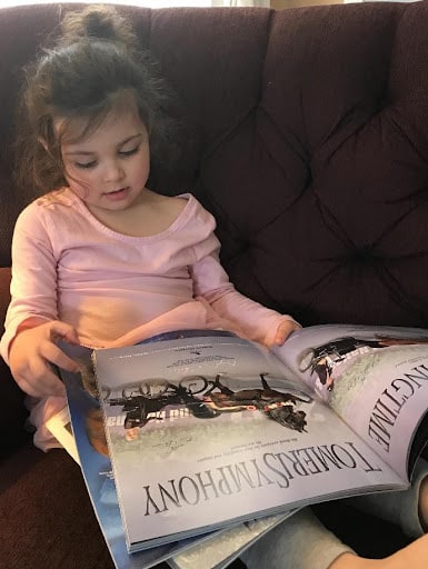 This is a great example of nonprofit storytelling via email. This image shows a young girl sitting on a couch reading a book. 