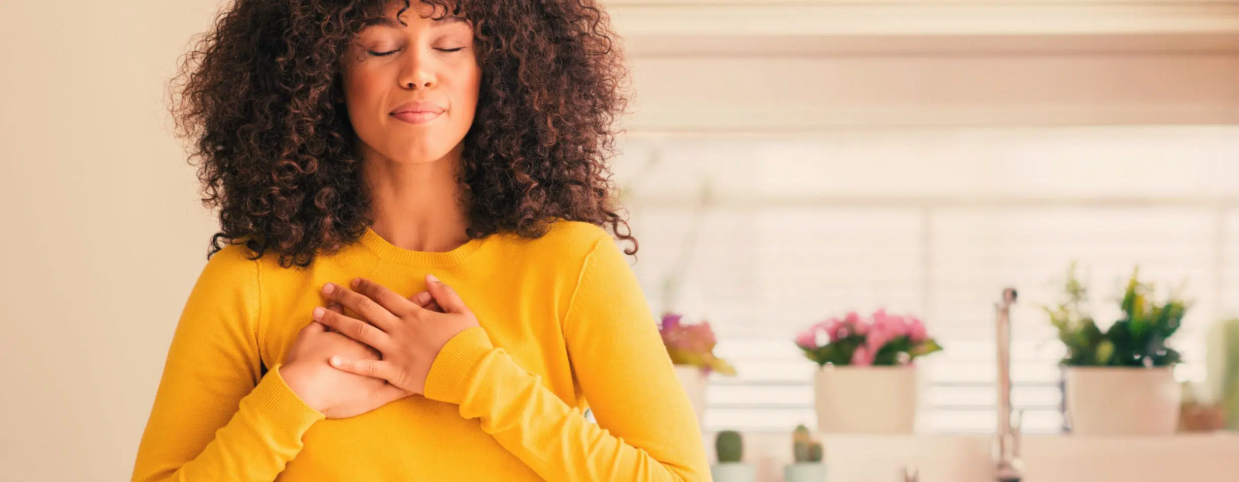A woman showing gratitude with hear hands over her heart.