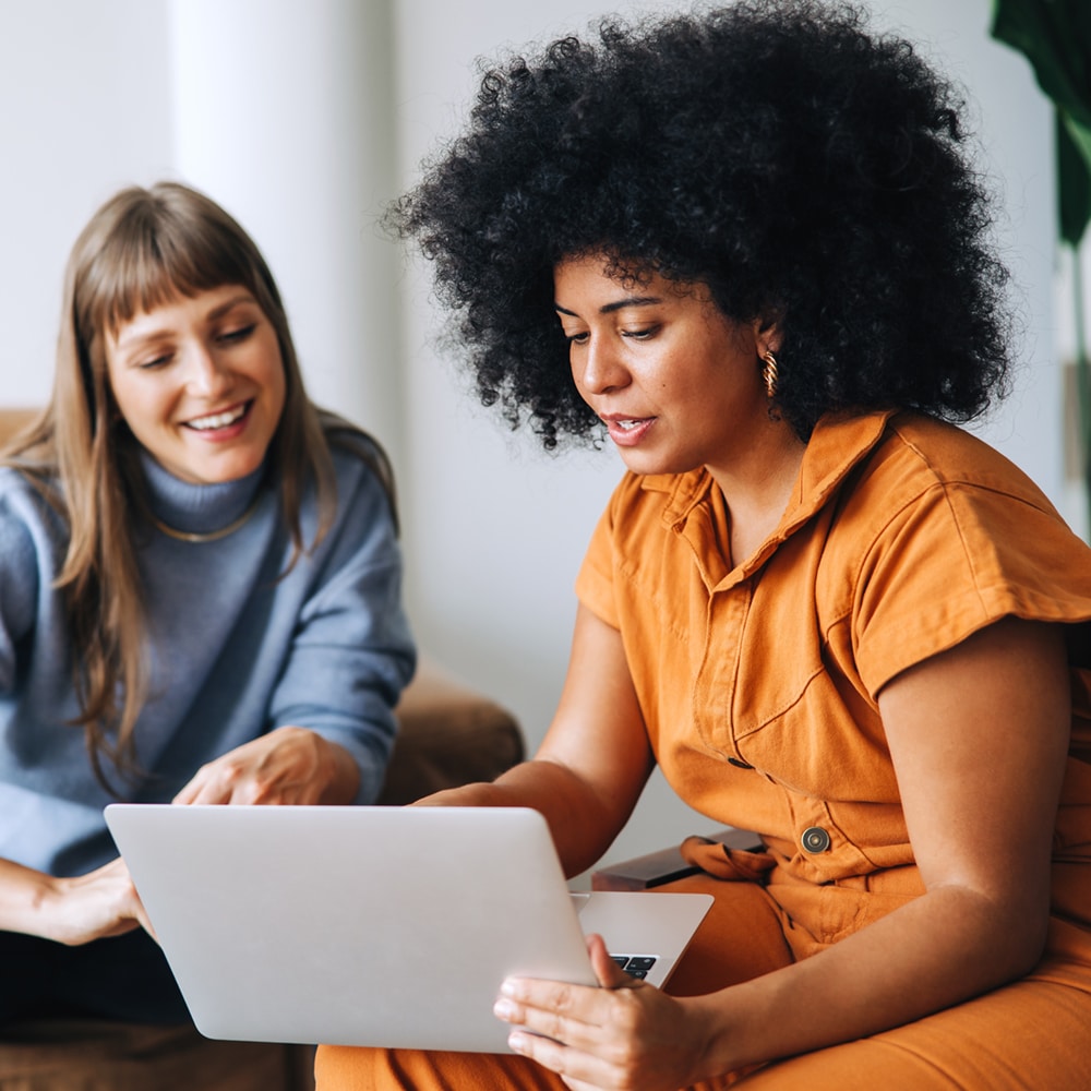 Businesswomen Having A Discussion While Using A Laptop In An Office
