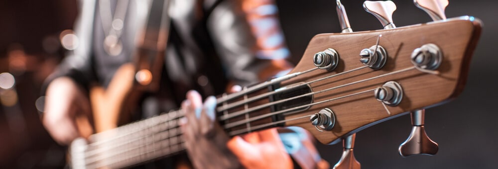 A man plays a guitar, representing the classic live auction items of concert tickets