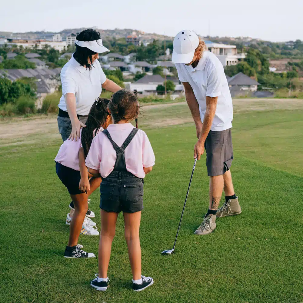 Adults and children playing golf