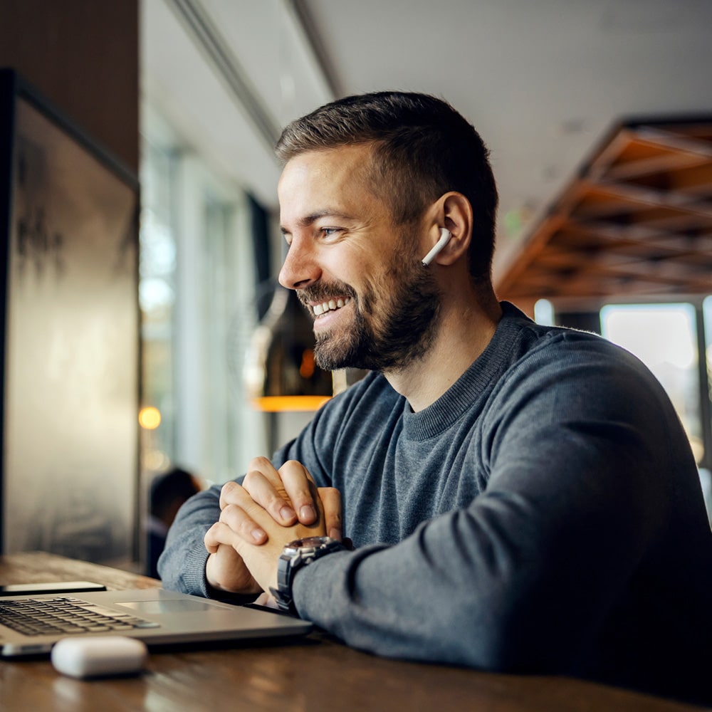 A Friendly Freelancer Is Sitting In A Coffee Shop And Having Con