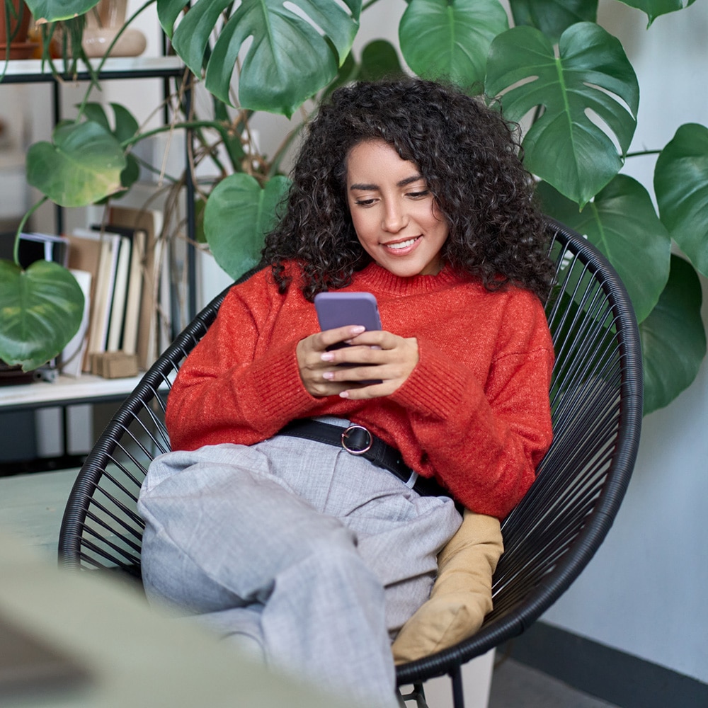 Woman in read sweater looking at phone