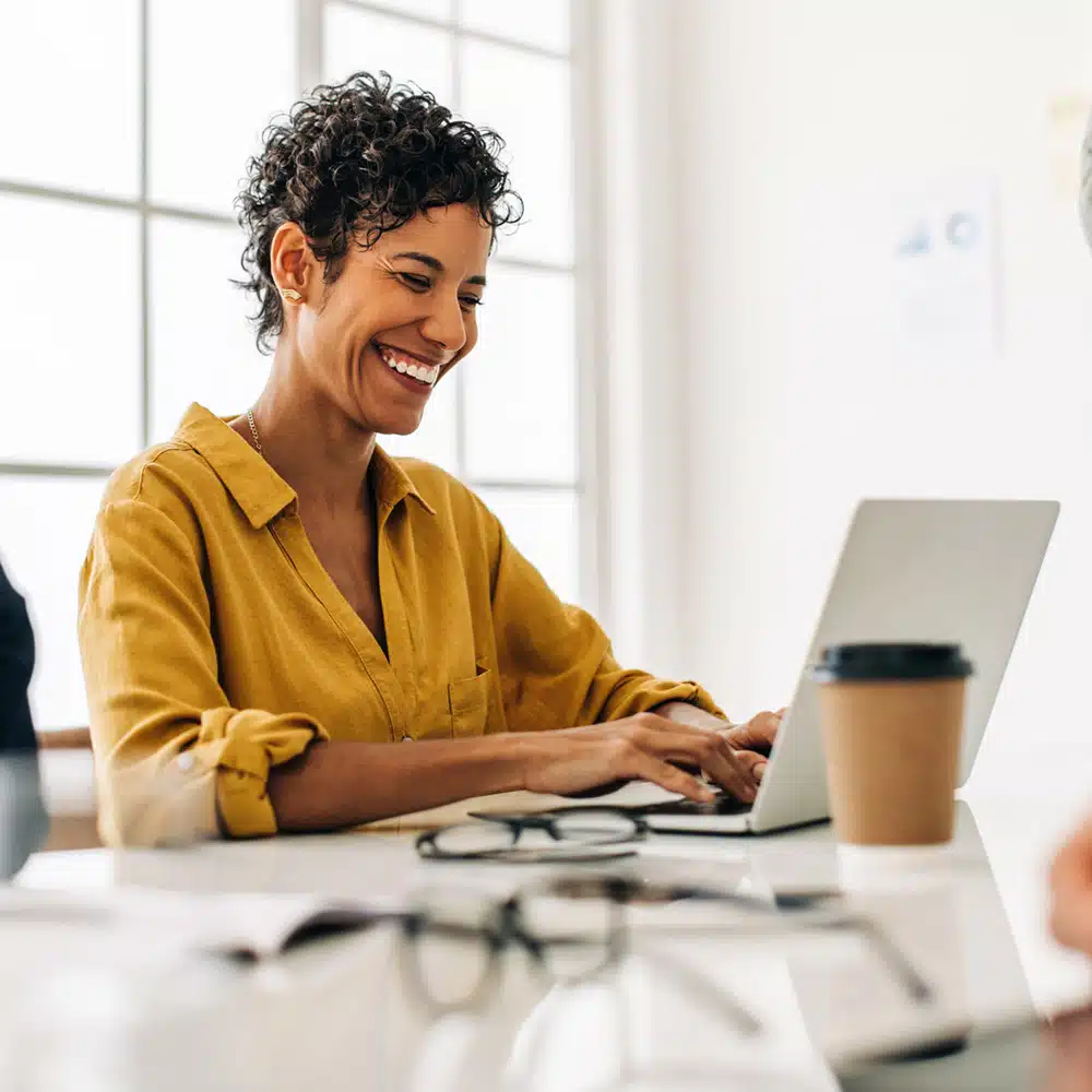 Business Woman Using A Laptop In A Meeting With Her Team