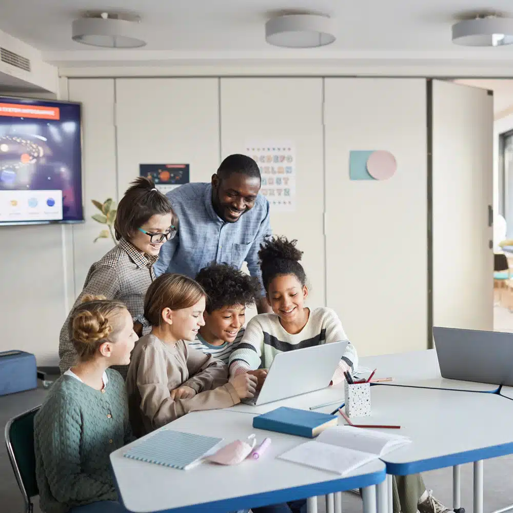 Group Of Kids Looking At Computer Screen In School