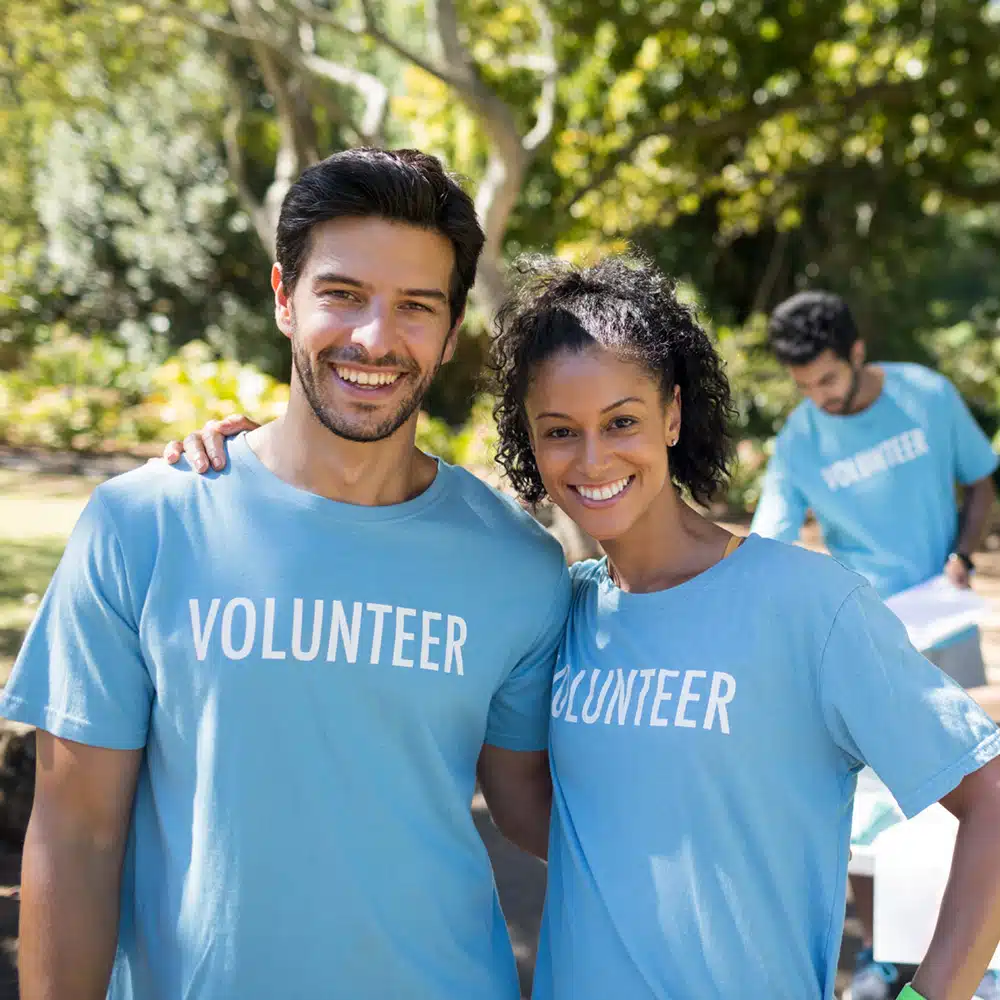 Smiling Volunteers Standing In The Park