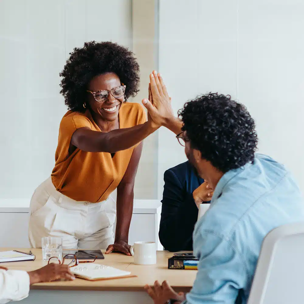 Man and woman high fiving in office