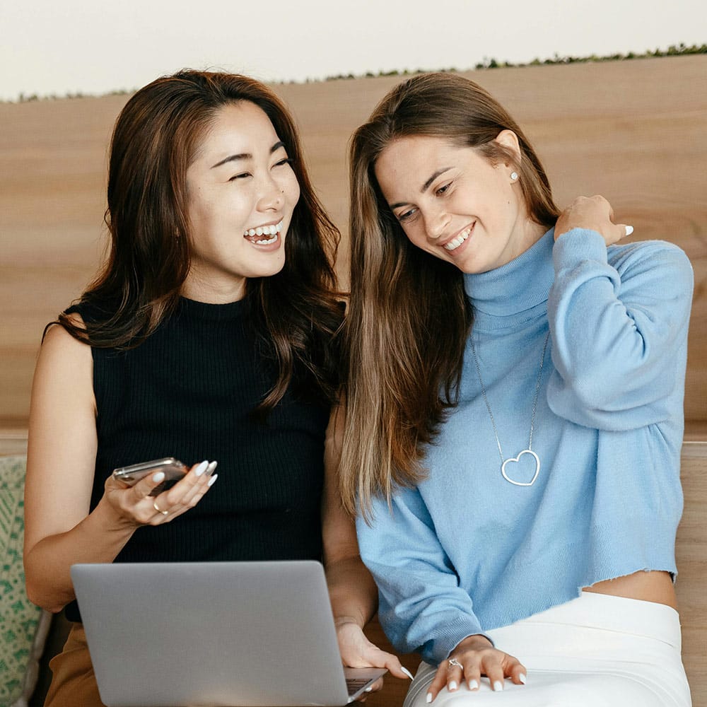 Two Women Smiling At Computer