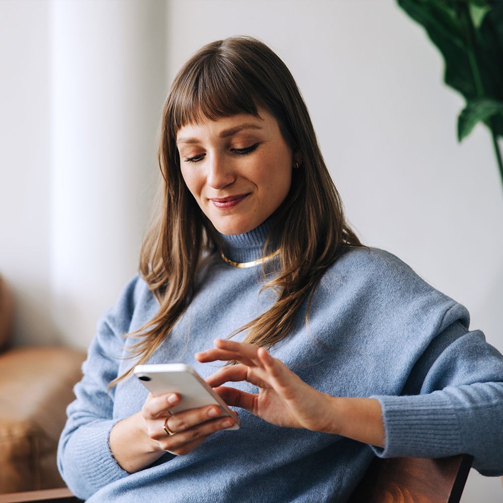 Woman on couch looking at phone