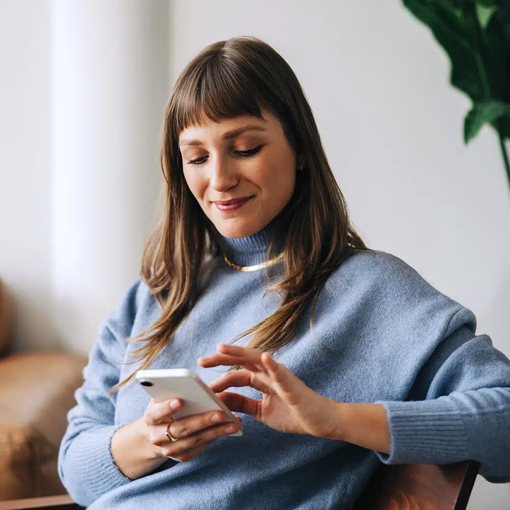 Woman on couch looking at phone