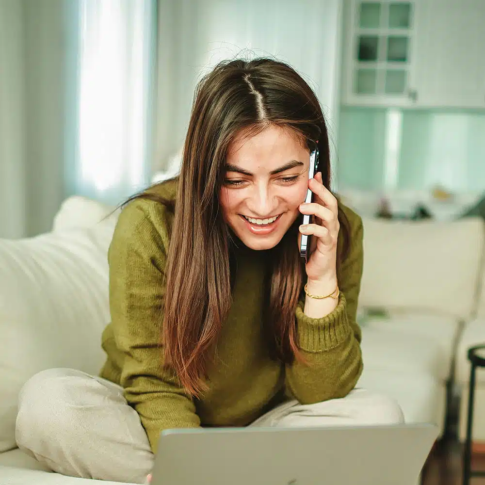 Woman smiling at computer on phone