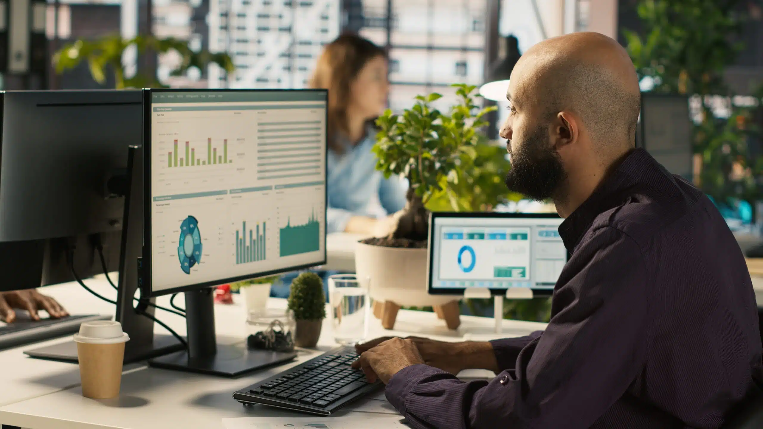 nonprofit worker at his computer looking at reports on in his crm